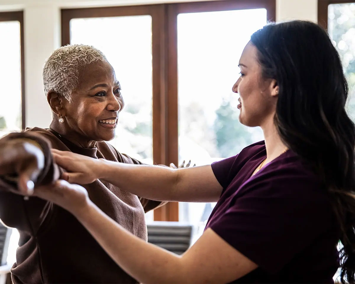 Physical therapist helping a woman with an arm stretch