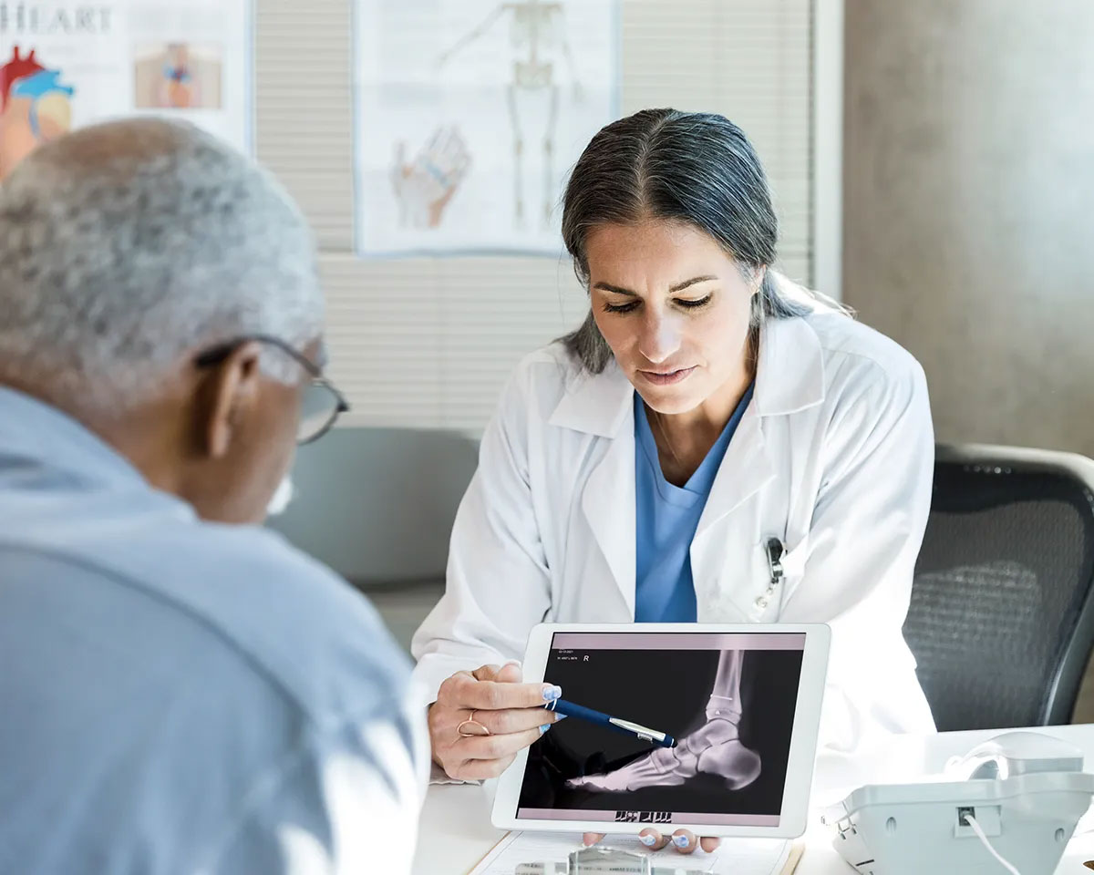 Doctor showing patient an xray on a tablet