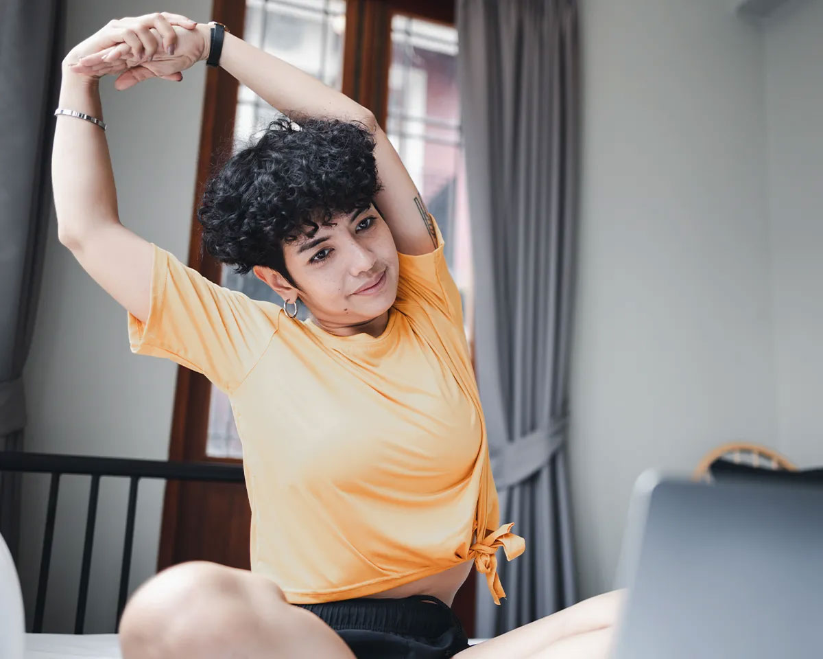 Woman sitting down and stretching her arms