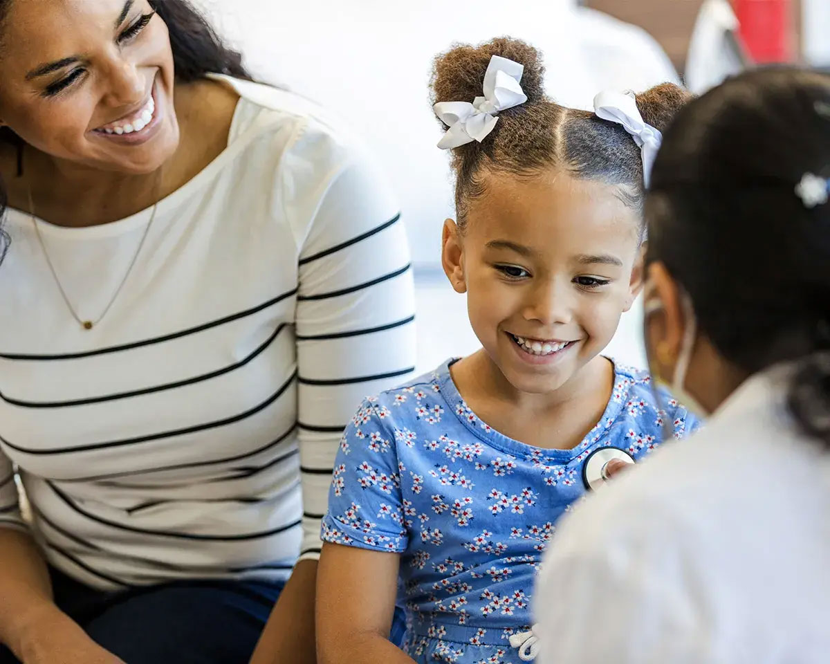 Doctor talking to mother and young daughter