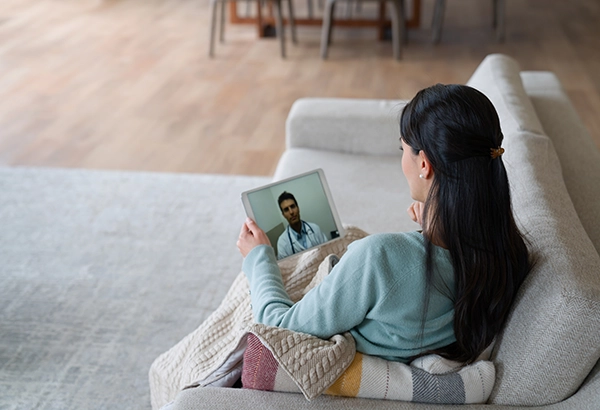 Woman sitting on couch having a call with a doctor