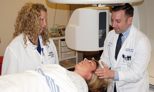 Two doctors examining a patient that's lying down