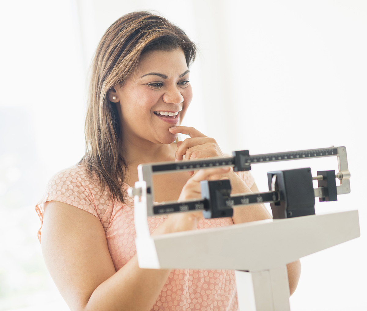 Woman smiling on a weight scale