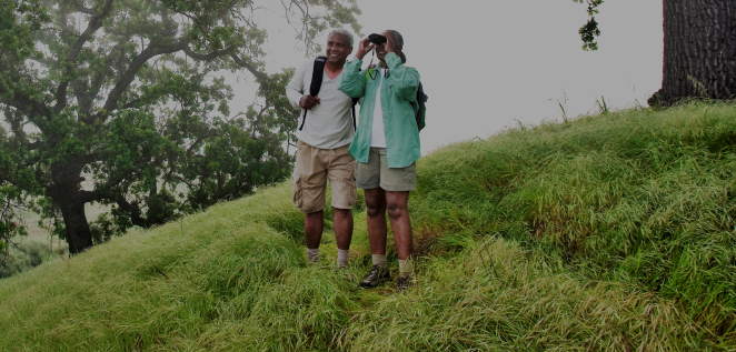 Man and woman exploring the outdoors, standing on a grass field