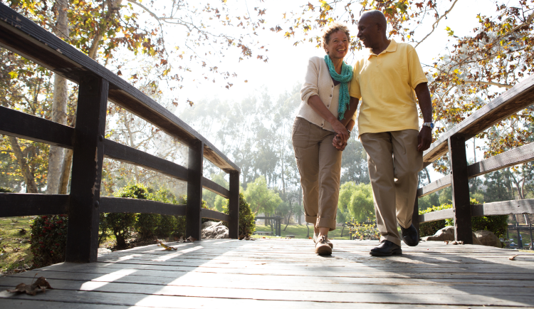 Woman and man walking on a bridge and holding hands