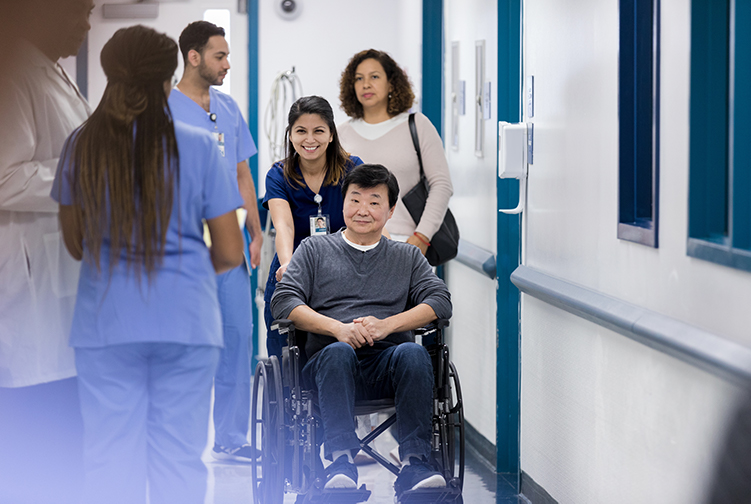 gentleman at the hospital in wheel chair pushed by provider