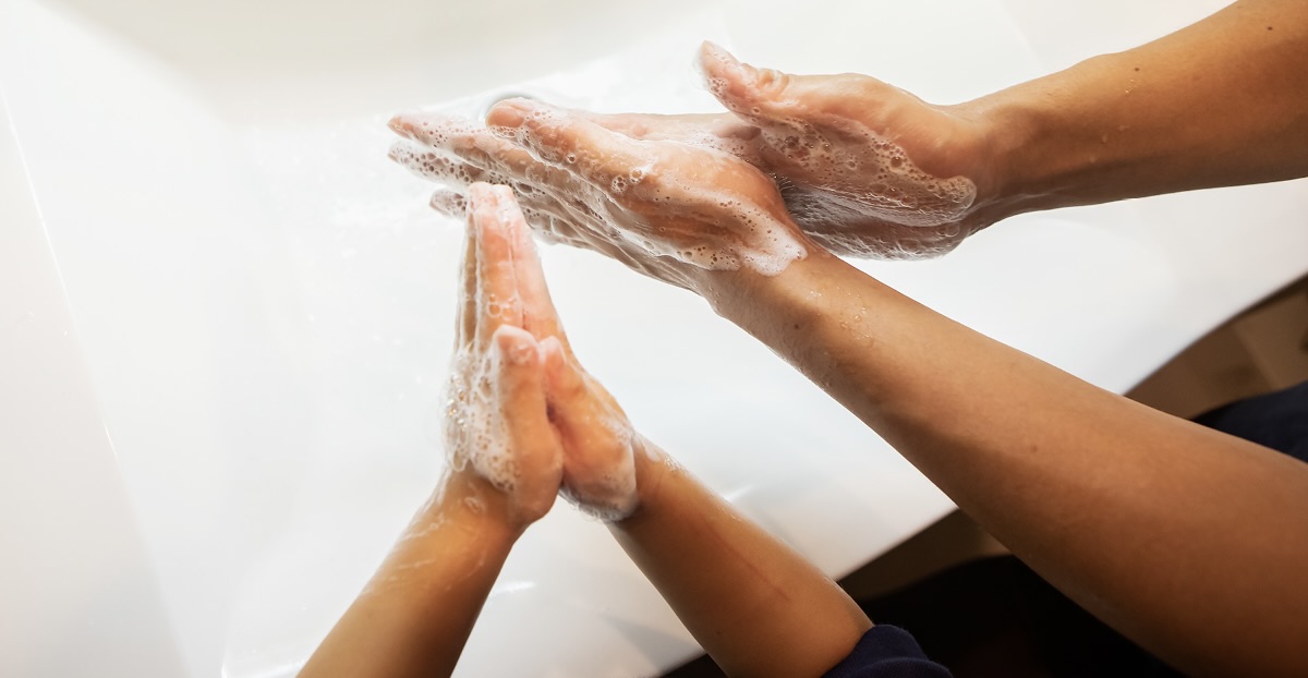 Two sets of hands washing with soap