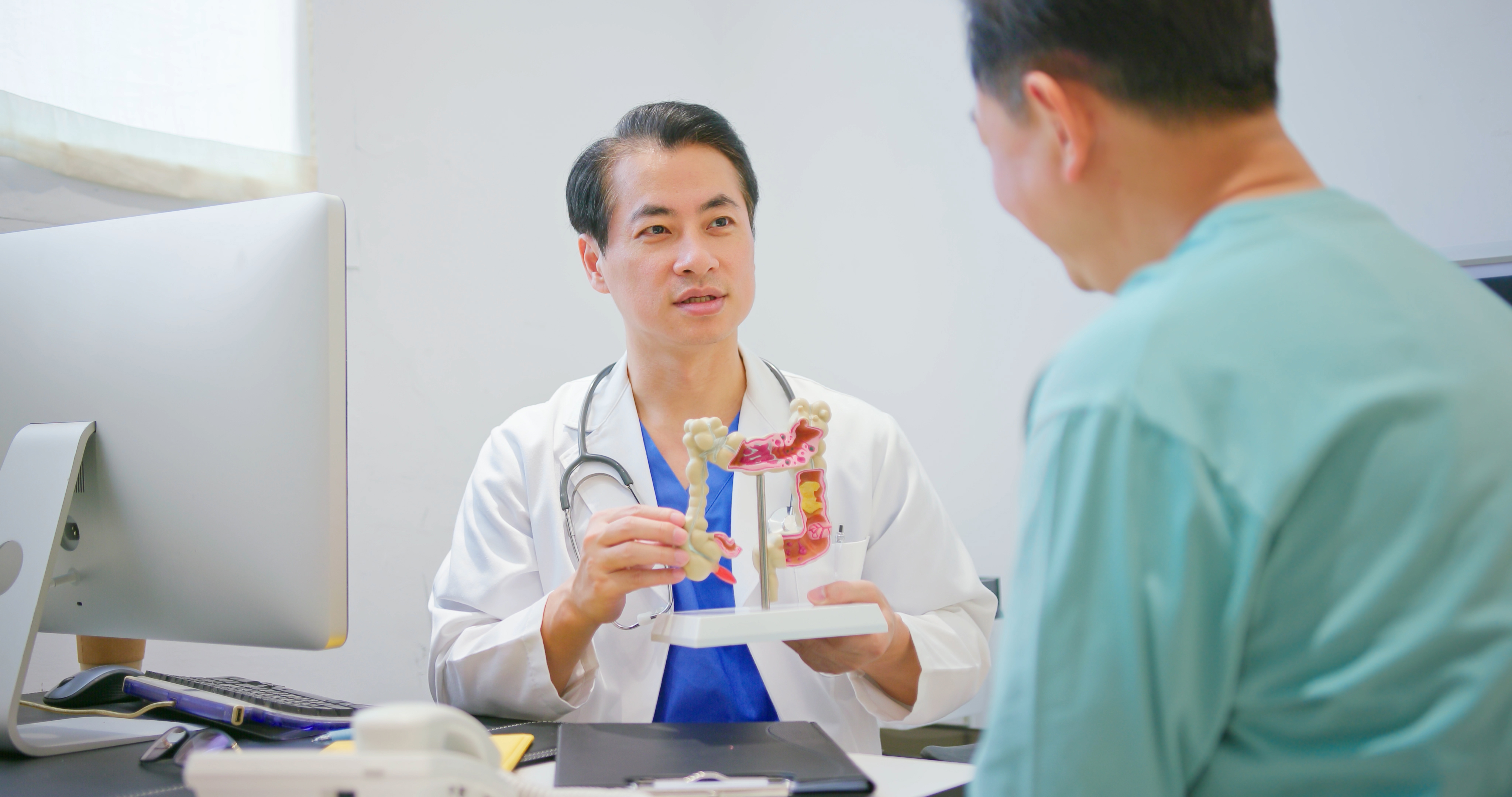 Colon screening being demonstrated by a provider to a patient using props