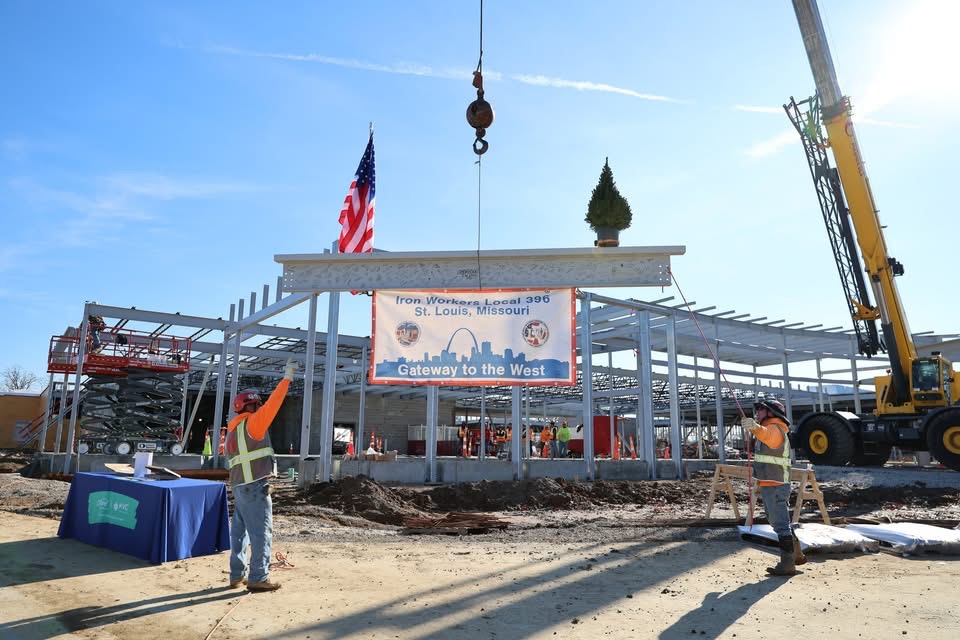 crane lowering banner over construction project