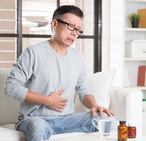Man sitting with his hand on his stomach