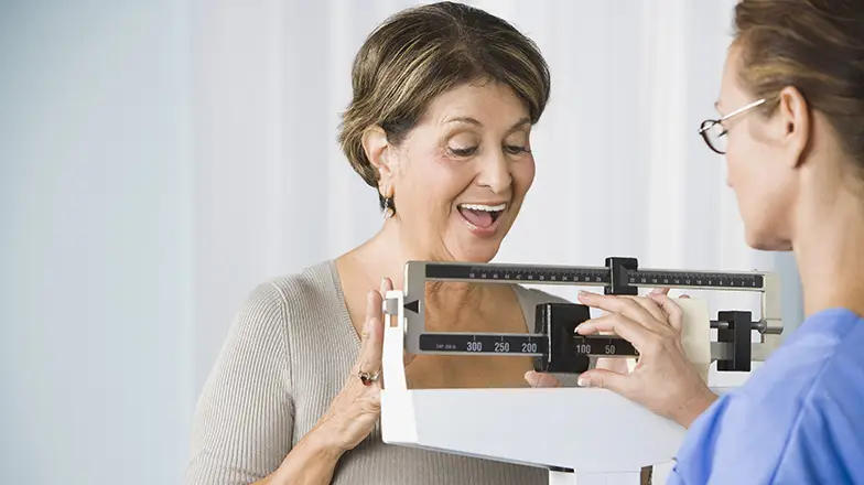 Woman weighing herself on scale