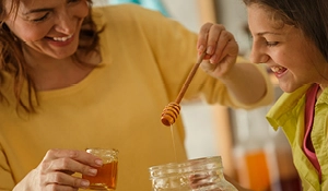 Two people working with honey