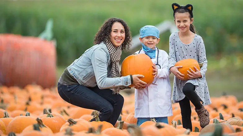 family holding pumkins