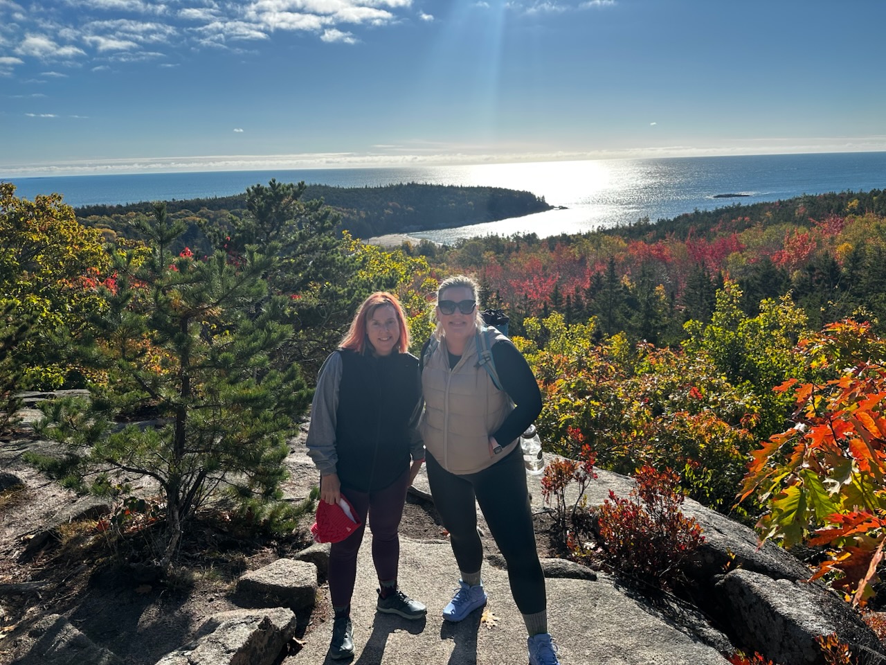 Heather and a friend on top of a rock formation during a hike