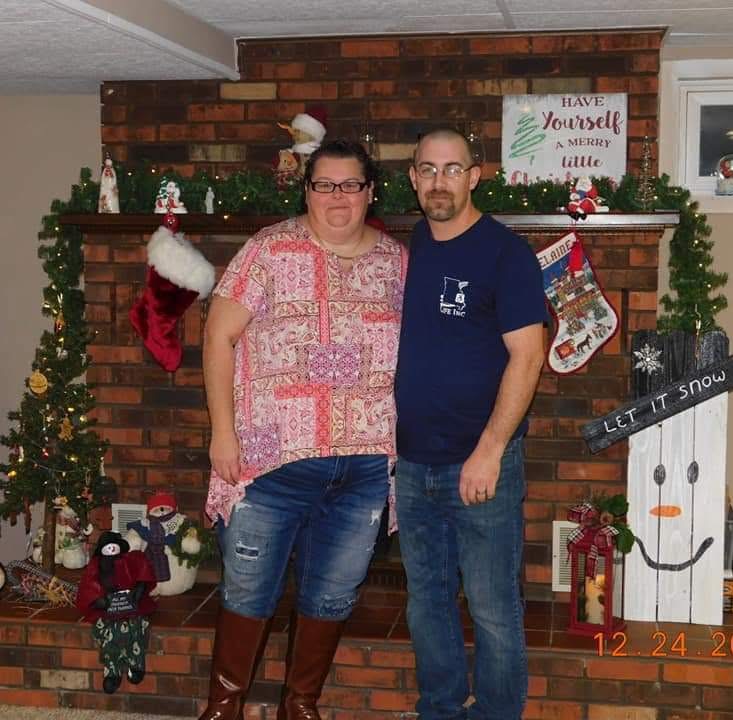Bruce and Andrea standing next to each other near Christmas decorations