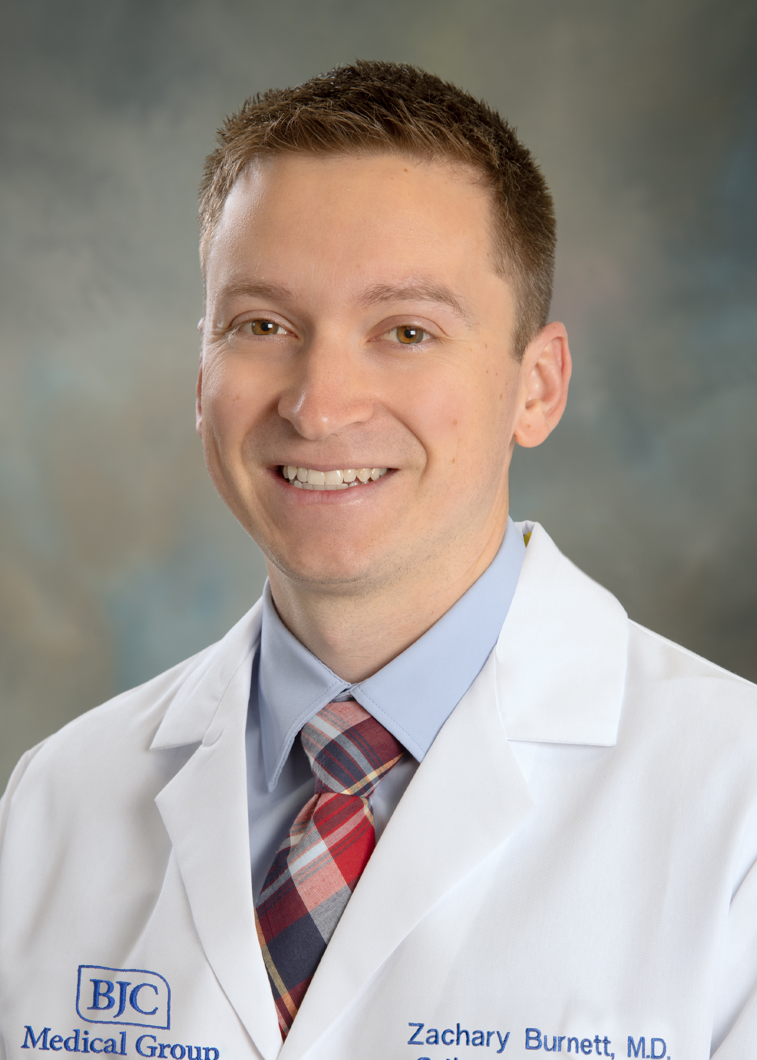 Headshot of Dr. Zachary Burnett in a white coat