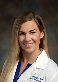 Headshot of Caitlin Rogers, DO, FAAFP wearing a white coat with stright, blonde hair