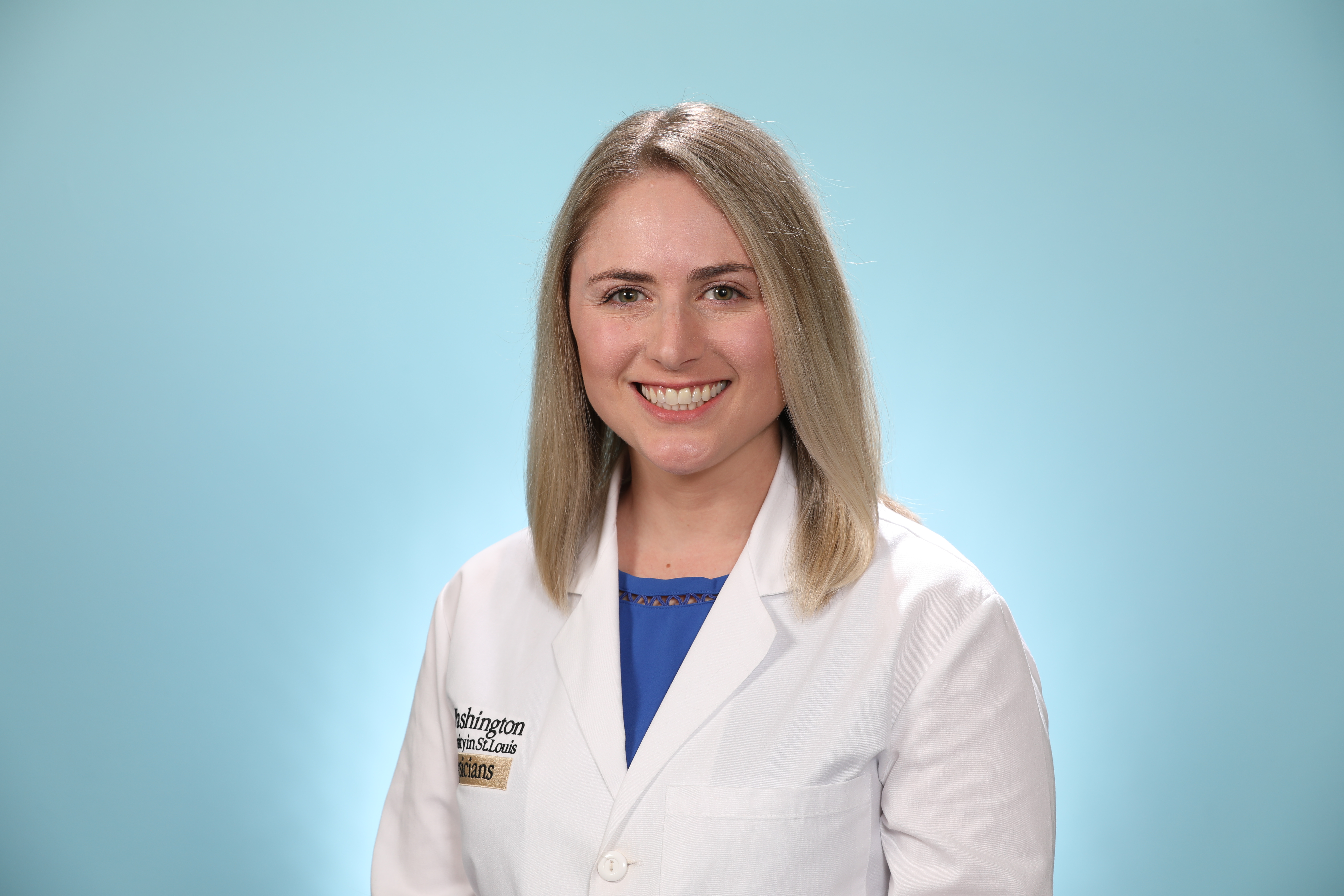 Headshot of Dr. Katherine Caldwell in a white coat and blonde hair against light blue background