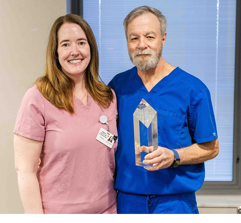 Dr. William “Bill” Johnson receiving the Excellence in Healthcare Award alongside Chief Medical Officer Dr. Kim Borchers.