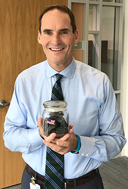 Rich holding a jar of coal