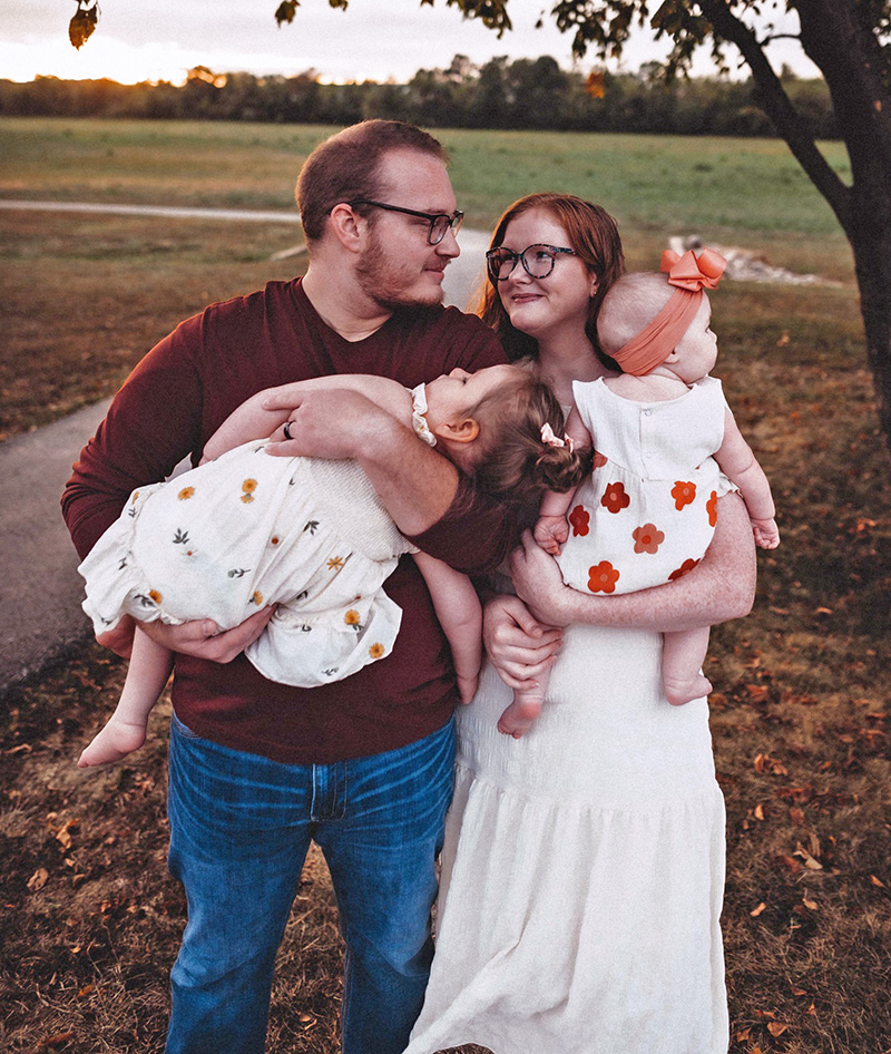 Sarai and her husband Parker holding their daughters Scarlette and Adeline.