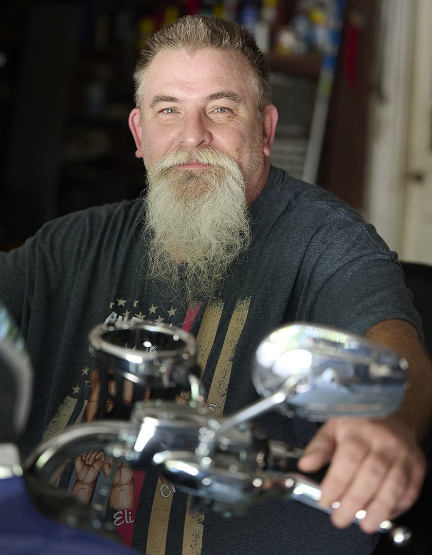 Patient William Jeremias sitting on his beloved motorcycle after recovery.