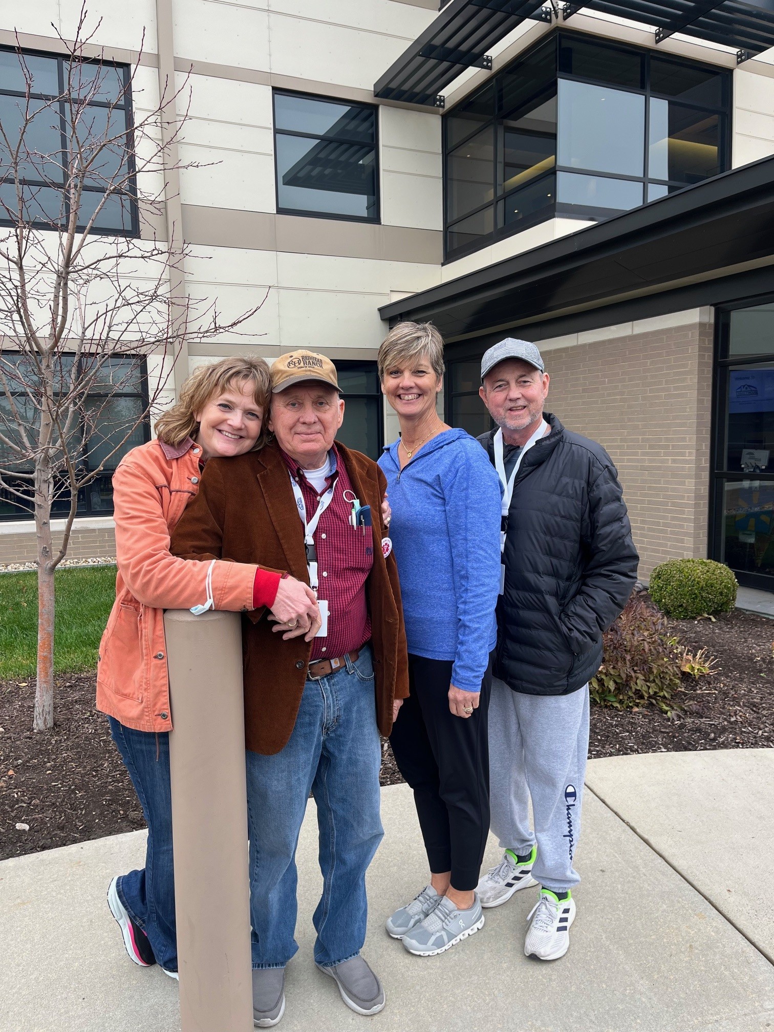 Keith Waterman (center) with his wife Amy (left) pose for a photo outdoors alongside  pose for a photo with Caren Fielder and her husband, David Fielder 