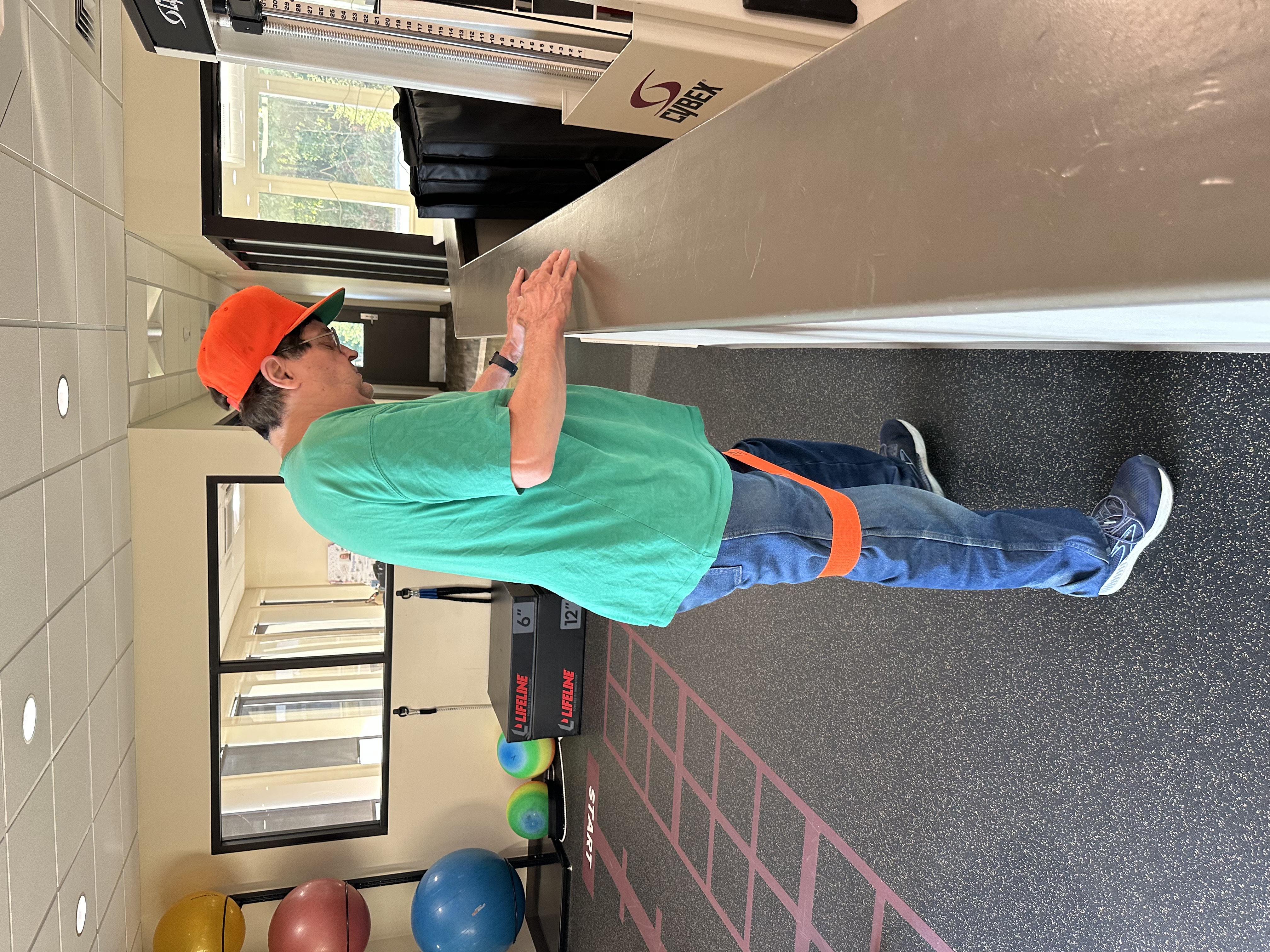 Robert Furlow stands with resistance bands on knees.