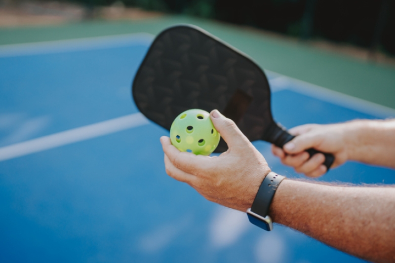 Someone playing pickleball about to serve the ball