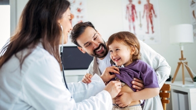 Child being examined by a doctor while the father is holding the child
